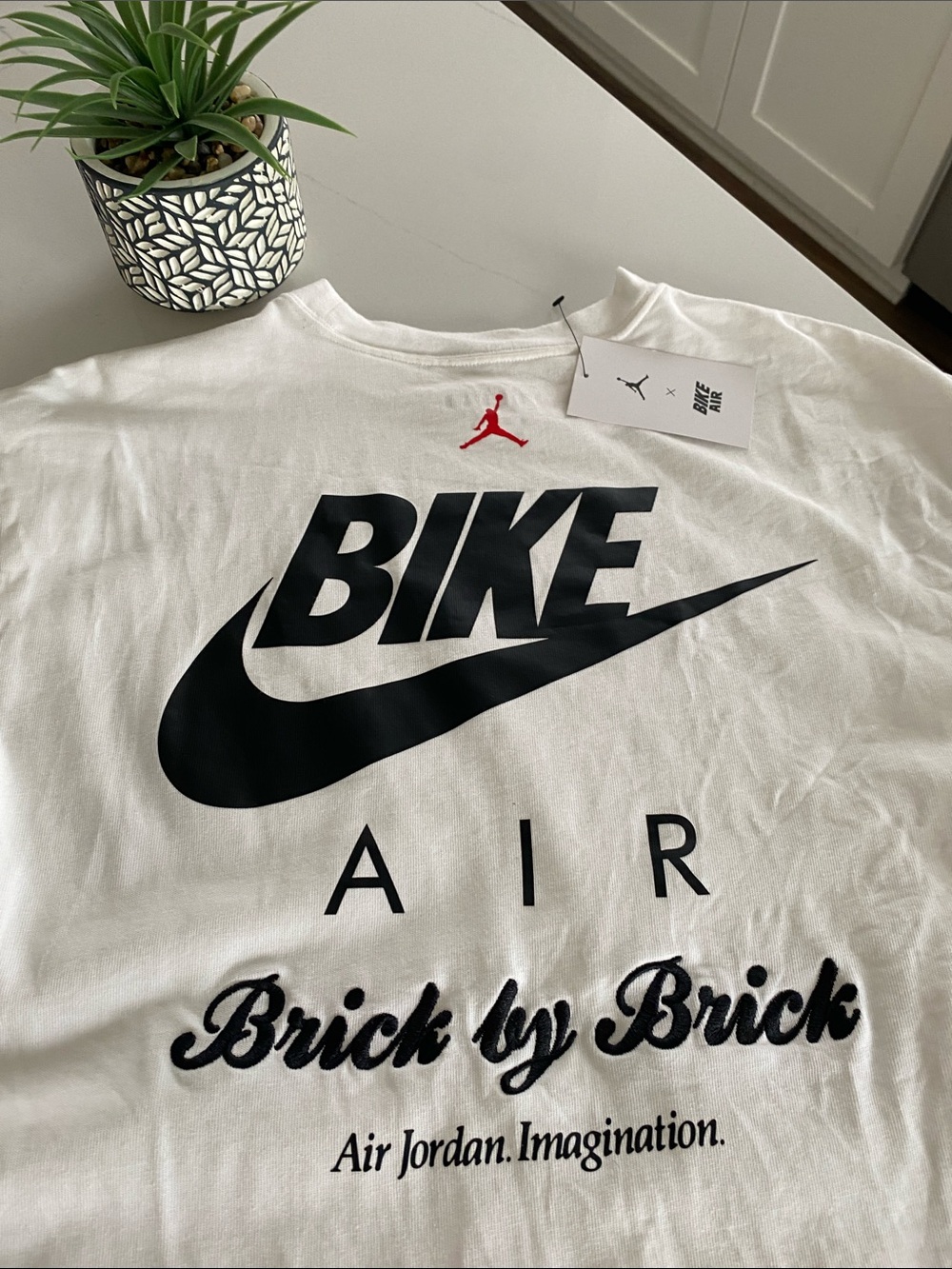Nigel Sylvester White Tee with Black 'BIKE' Graphic and Red Jumpman Accent